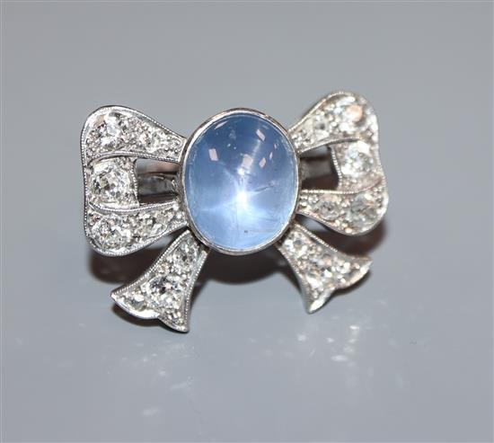 A plat, cabochon star sapphire and diamond set ribbon bow dress ring, size M/N.